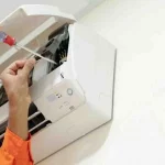 Técnico revisando unidad interior de aire acondicionado